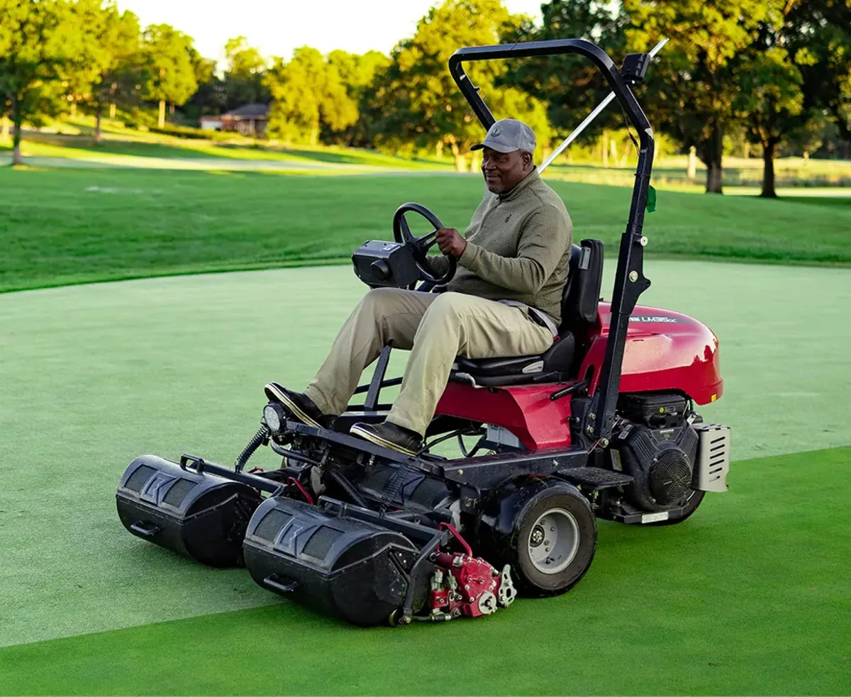 Superintendent mowing a green on a Baroness triplex mower
