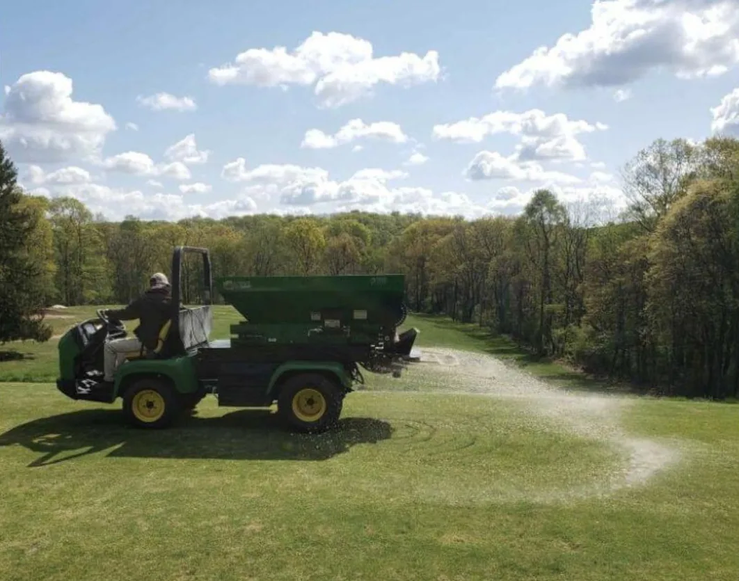 Turf Time GT-100 topdresser mounted on a utility vehicle spreading on a fairway